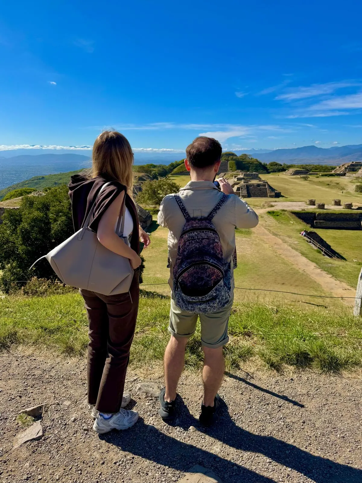 Tour privado en Oaxaca - Viajeros contemplando la Gran Plaza de Monte Albán